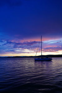 Sailboat sailing on sea against sky during sunset