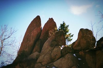 Low angle view of rock formations against blue sky