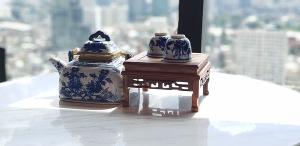 Teapot with cups on marble table