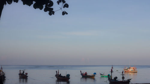 Boats moored in sea against sky