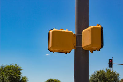 Low angle view of signal on pole against sky