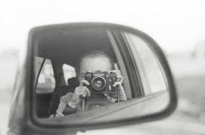 Portrait of man photographing through camera