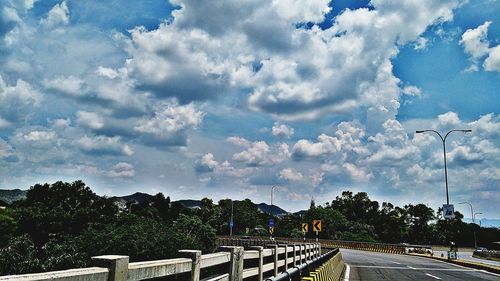 Road by trees against sky