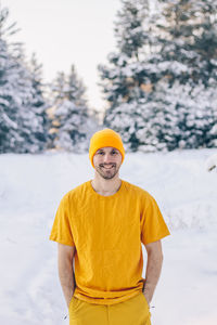 Portrait of smiling man standing in snow during winter