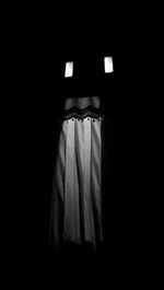 Close-up of illuminated lamp hanging against black background