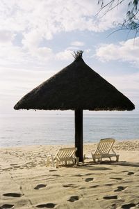 Chairs under the coconut beach umbrella against the beach in the sunset moment, phu quoc, vietnam