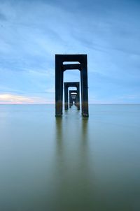 Built structure on pier over sea against sky