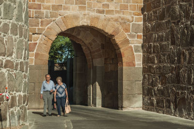 Full length of woman standing against wall