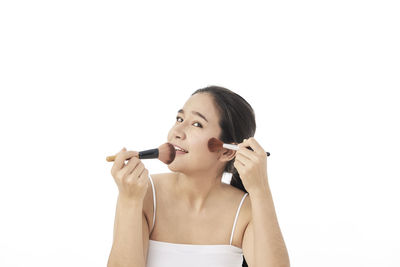 Portrait of young woman against white background