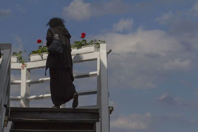 Rear view of woman standing against sky