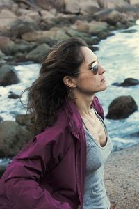 Beautiful woman contemplating the ocean with purple rain coat