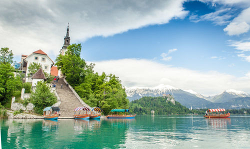 View of boats in lake against cloudy sky