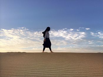 Full length of woman standing against sky