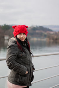 Young woman standing by lake