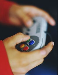 Close-up of cropped hands playing game at home