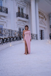 Full length of woman standing against building