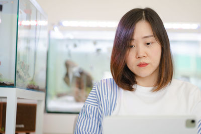 Portrait of young woman using mobile phone at cafe
