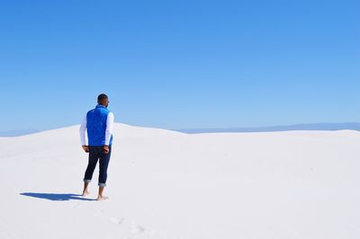 Woman standing on landscape against clear sky