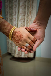 Cropped image of couple holding hands