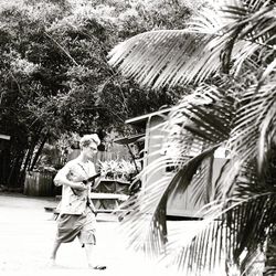 Side view of man with umbrella walking on plants