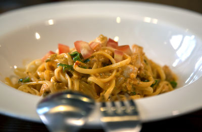 Close-up of silverware on bowl with spaghetti at table