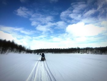 Man on snow covered landscape against sky