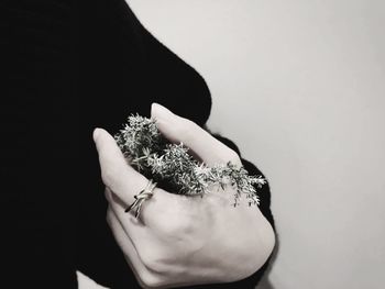 Close-up of woman holding hands against white background