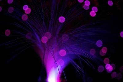 Defocused image of illuminated lights against black background