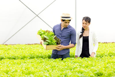 Young couple holding hands on plants