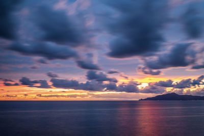 Scenic view of sea against dramatic sky during sunset