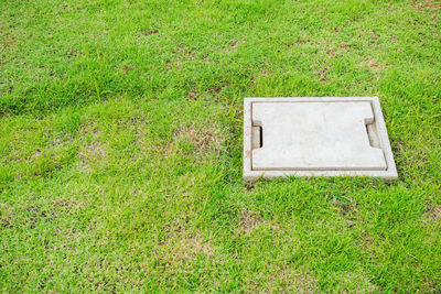 Concrete pipe cover on lawn. pond in the garden drainage system with green grass.