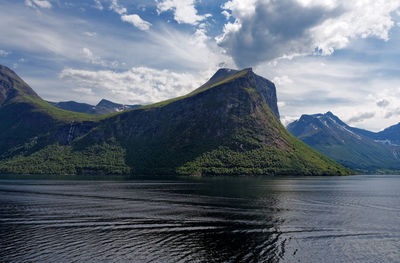 Scenic view of lake by mountains against sky