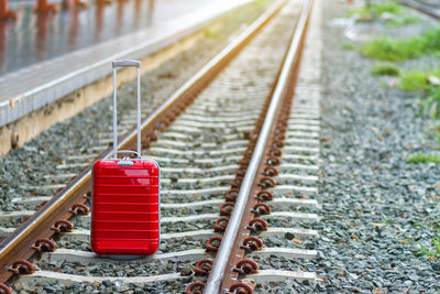 Close-up of wheeled luggage on railroad tracks