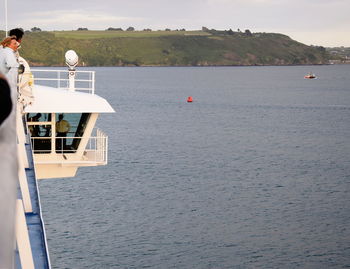 People on boat in sea against sky