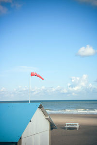 Flag on beach against sky