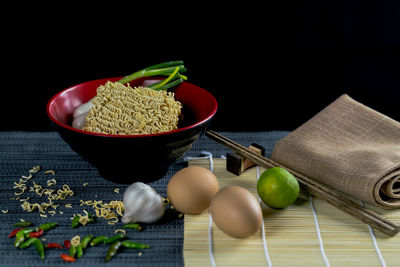 Close-up of vegetables in bowl on table against black background