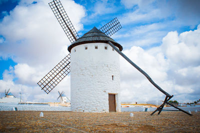 Low angle view of windmill against cloudy sky