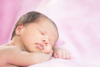 Close-up of baby sleeping in bed