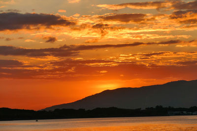 Scenic view of silhouette mountains against romantic sky at sunset