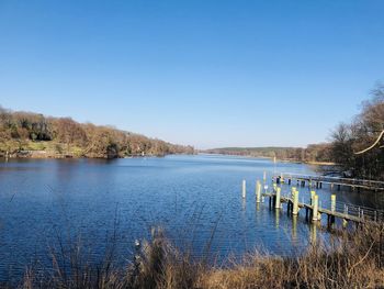 Scenic view of lake against clear blue sky