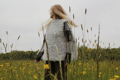 Woman standing on field against sky