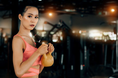 Beautiful woman looking away while standing against blurred background