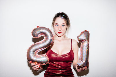 Portrait of young woman with eyes closed against white background