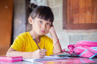 Portrait of a smiling girl sitting on table