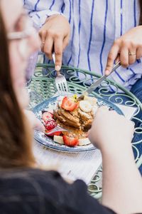 Midsection of woman holding ice cream on table