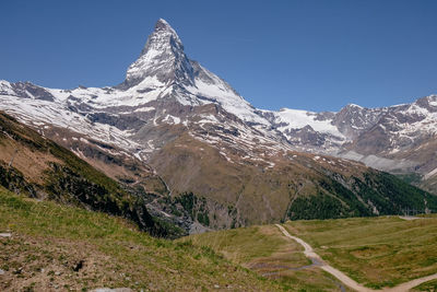 Scenic view of snowcapped mountains against clear sky