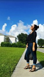 Full length of man standing on footpath against sky