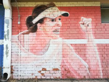 Full length portrait of woman against brick wall