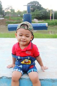 Cute smiling boy sitting in park