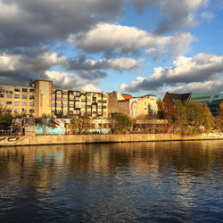 Buildings in city against cloudy sky